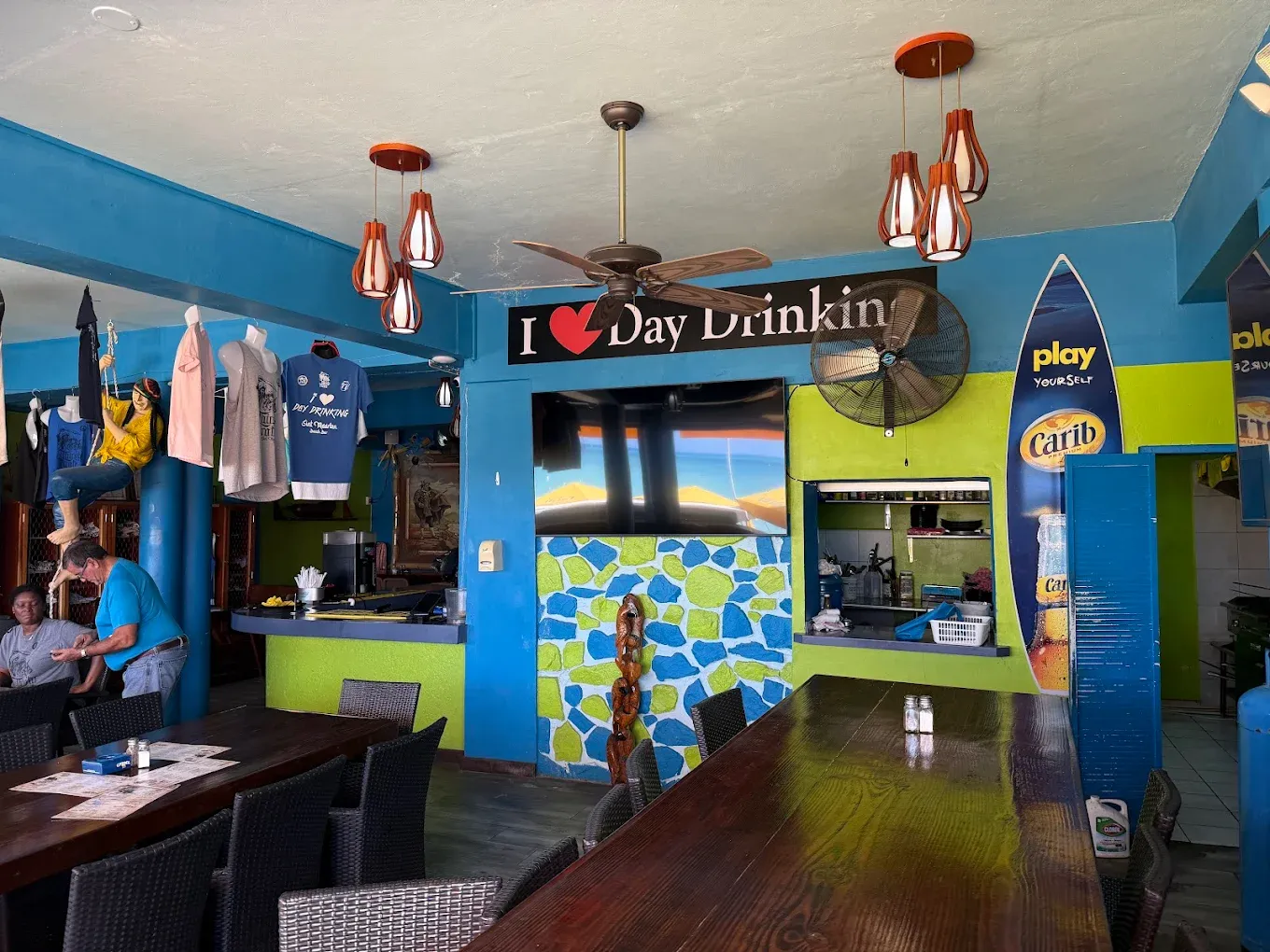 Colourful blue and green interior of Thirsty Pirate with an "I love Day Drinking" sign above the bar
