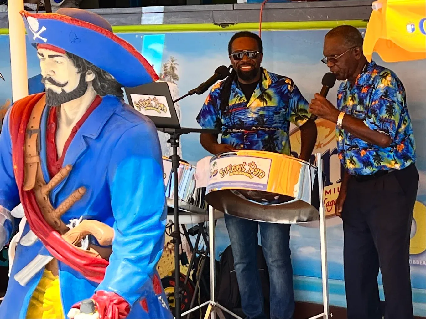 Live steel-pan musicians performing beside the pirate statue at Thirsty Pirate Beach Bar in Philipsburg