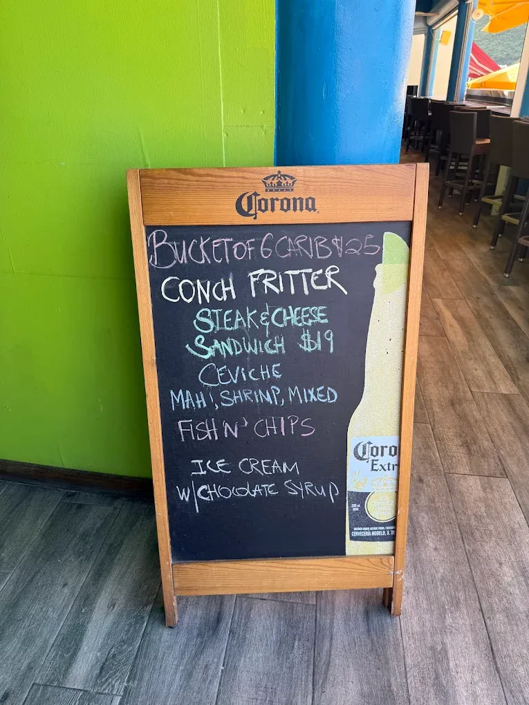 Daily specials board at Thirsty Pirate: bucket of Carib, conch fritters, steak & cheese, ceviche and fish & chips
