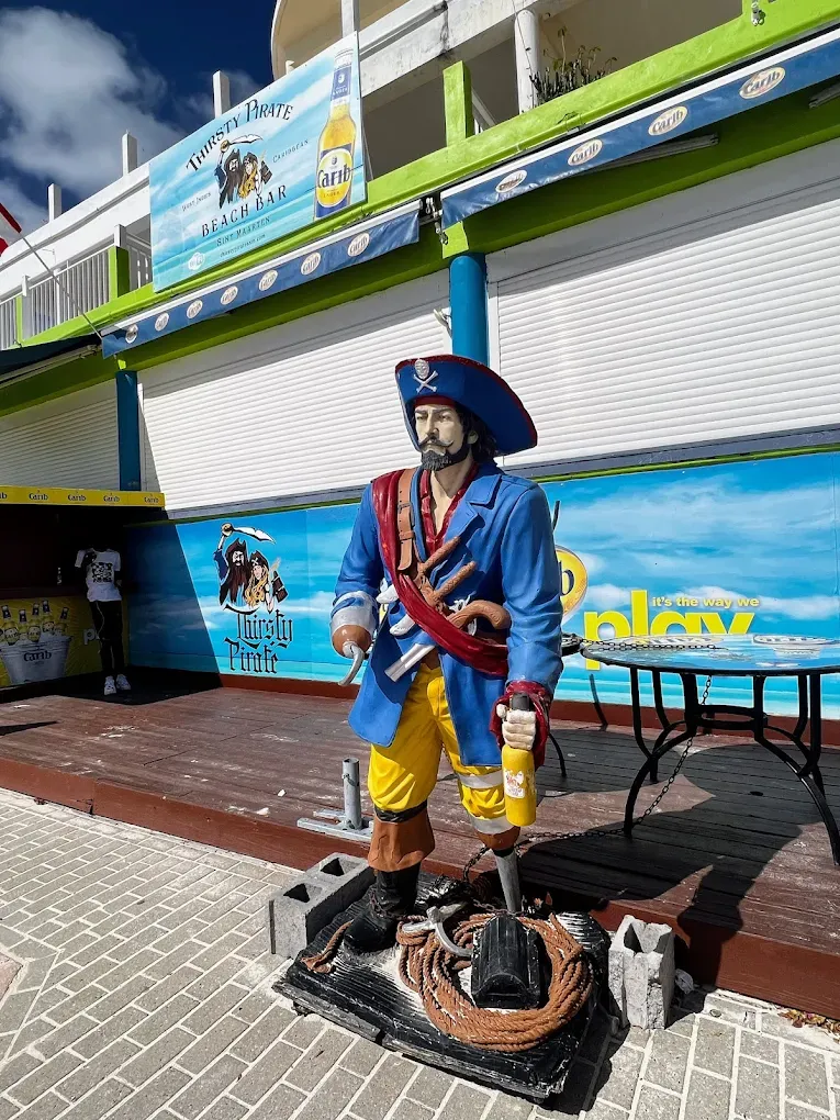 Life-size pirate statue standing guard at the entrance to Thirsty Pirate Beach Bar on the Philipsburg boardwalk