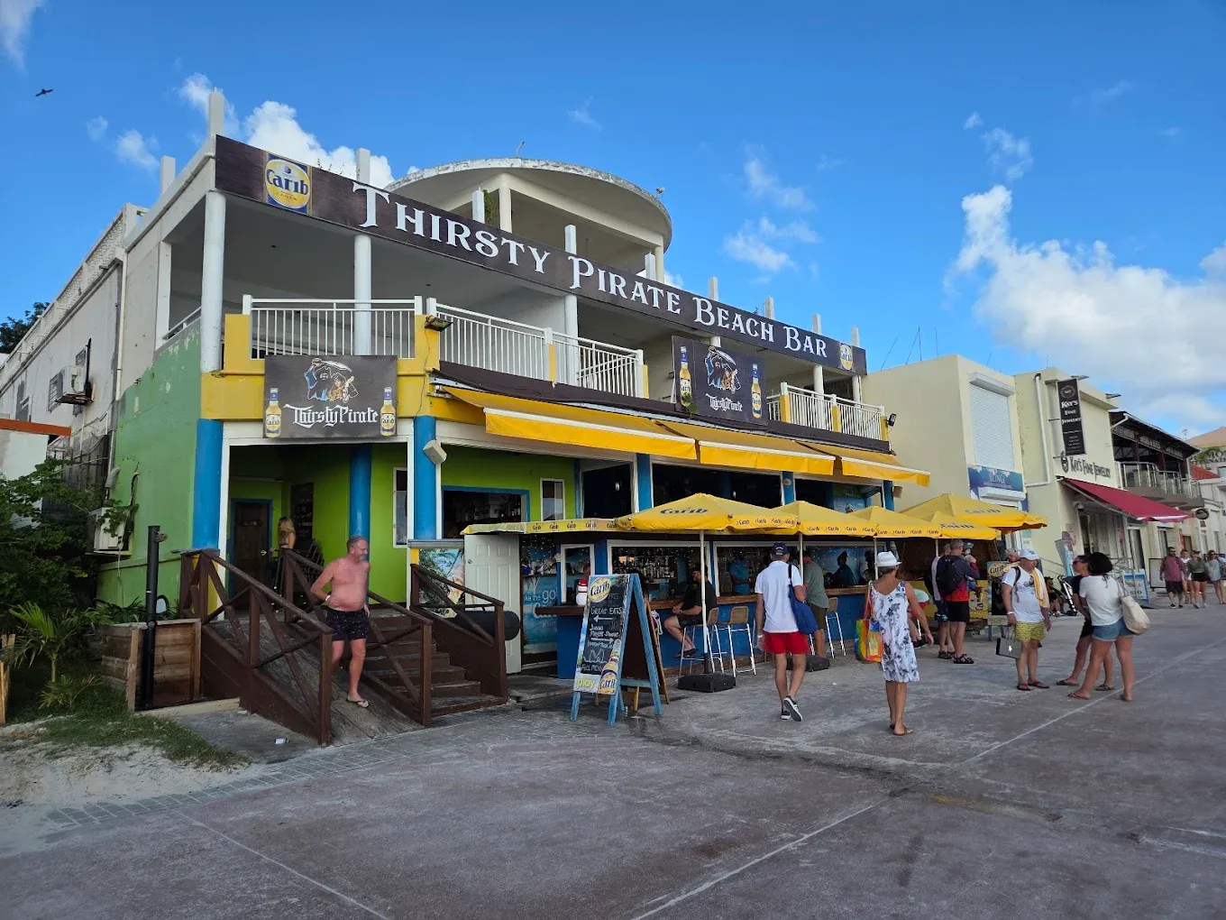 Thirsty Pirate Beach Bar & Grill seen from the Front Street boardwalk in Philipsburg, Sint Maarten, with cruise visitors walking past